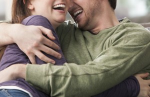 Caucasian couple hugging on sofa